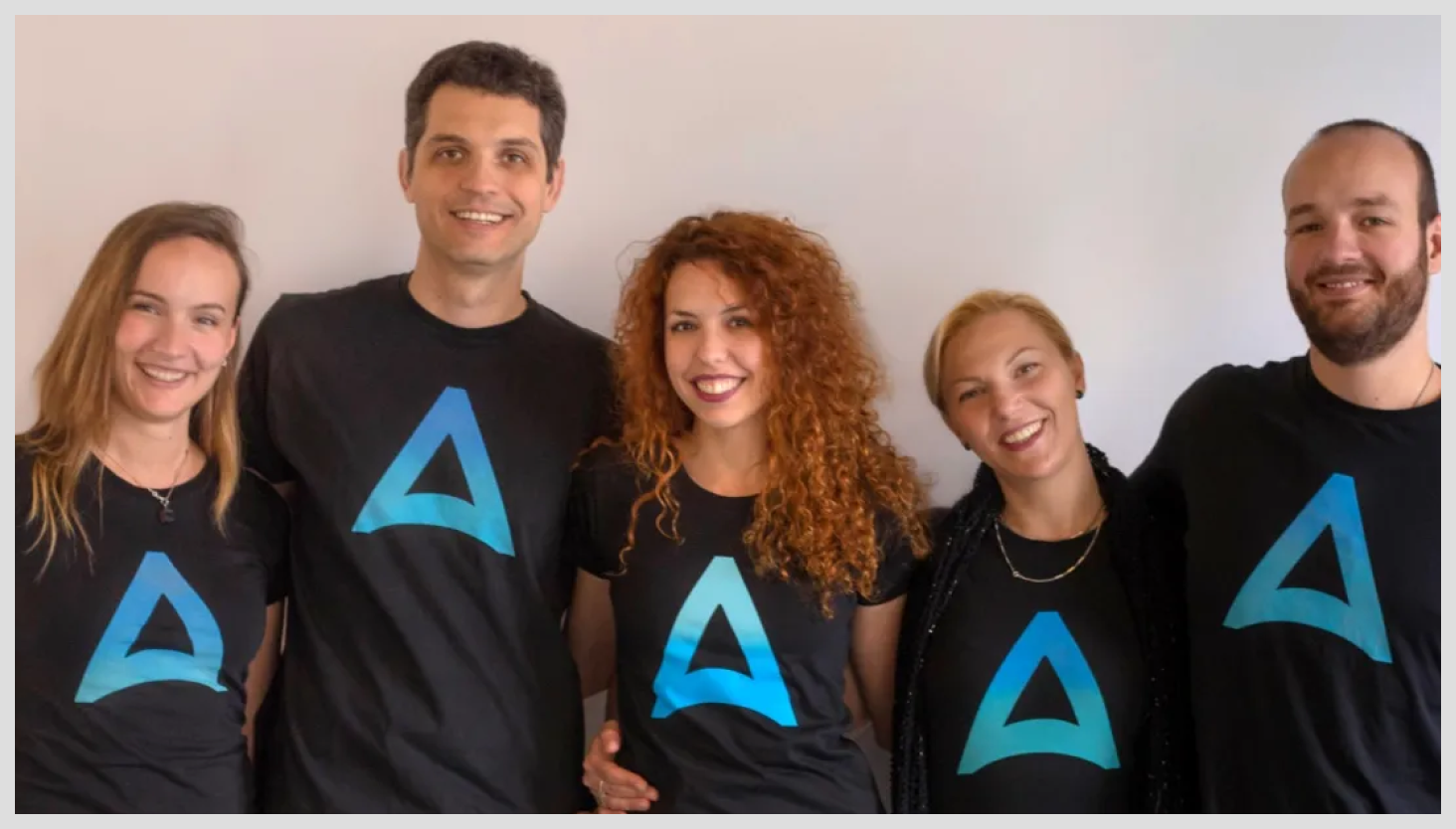 Five Alchemy Cloud employees wearing a shirt with the Alchemy Cloud logo